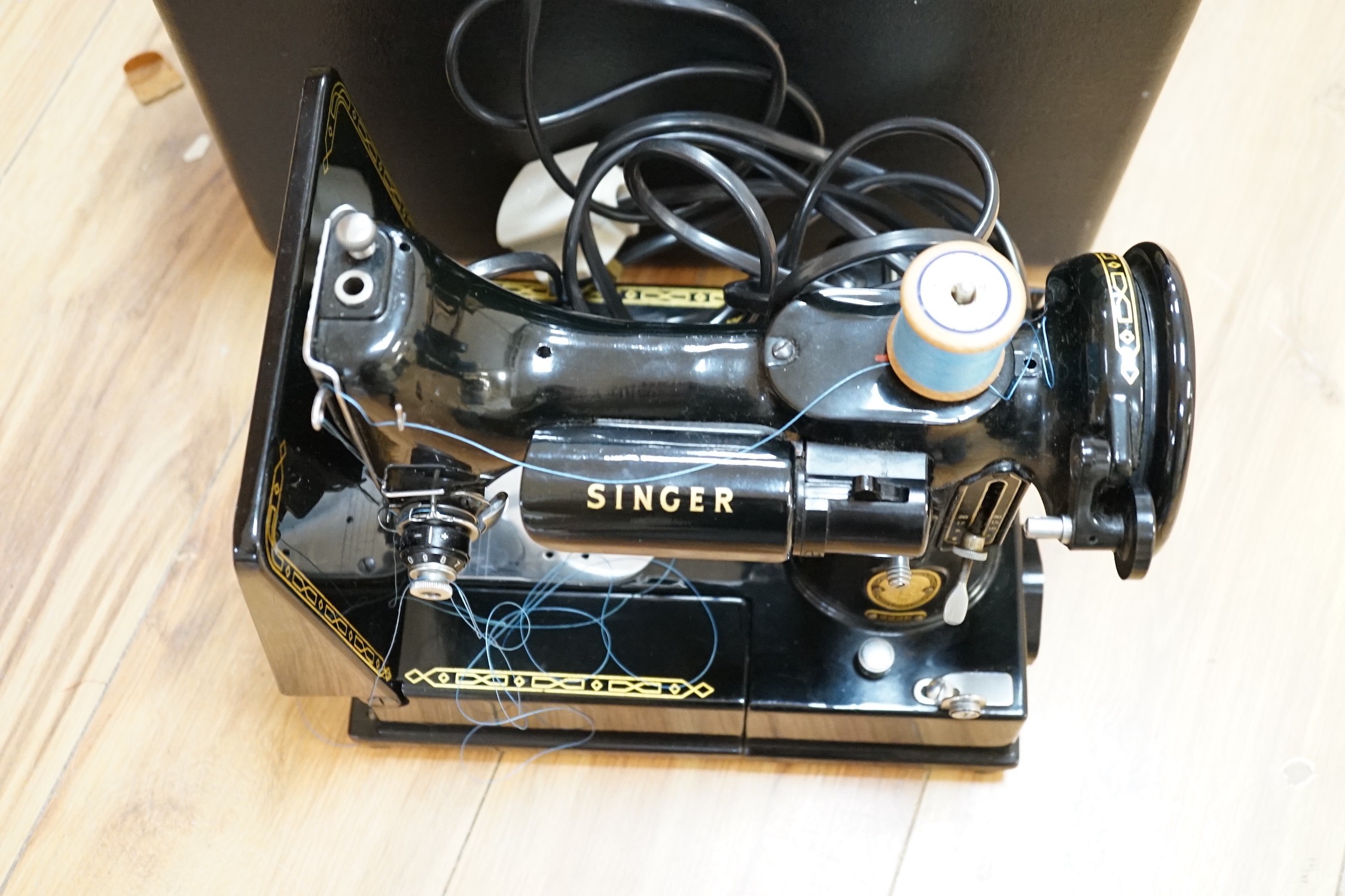 A cased portable Singer Featherweight 222K sewing machine with accessories